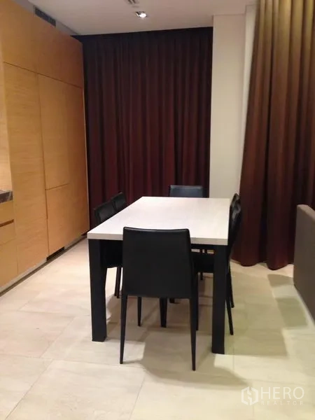 公寓 出售在Bang Rak, Bangkok - 餐区设四把黑色餐椅与长方形餐桌，旁有高窗帘。