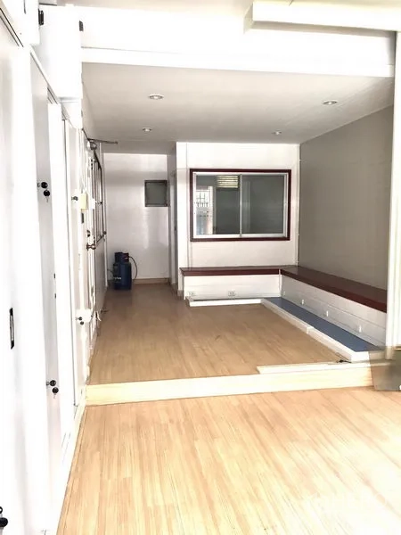 ทาวน์เฮาส์ ให้เช่าในWatthana, Bangkok - ห้องยาวปรับใช้ได้หลากหลาย พื้นไม้โทนอ่อน ไฟดาวน์ไลต์ และหน้าต่างภายใน เหมาะเป็นออฟฟิศหรือเก็บของ