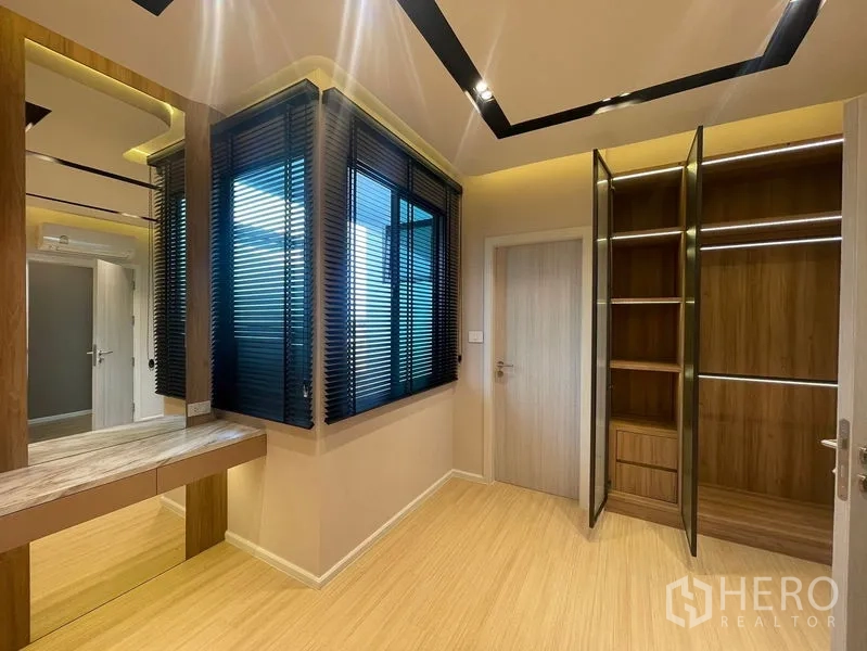 Townhouse for sale - Dressing room with corner windows, vanity table and built‑in open wardrobes.