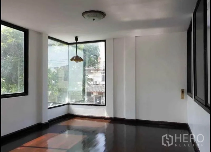 บ้าน ให้เช่าในLat Phrao, Bangkok - ห้องมุมชั้นบน หน้าต่างกระจกขนาดใหญ่ โคมแขวน และพื้นไม้เงา