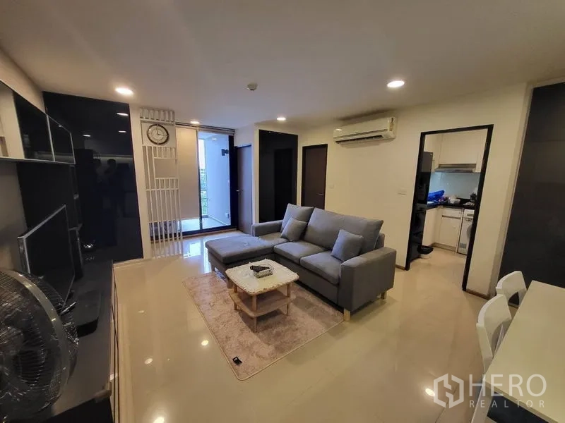 คอนโด ให้เช่าหรือขายในPhaya Thai, Bangkok - มุมห้องนั่งเล่นหันสู่ทางออกระเบียง พร้อมครัวแยกและเครื่องปรับอากาศ