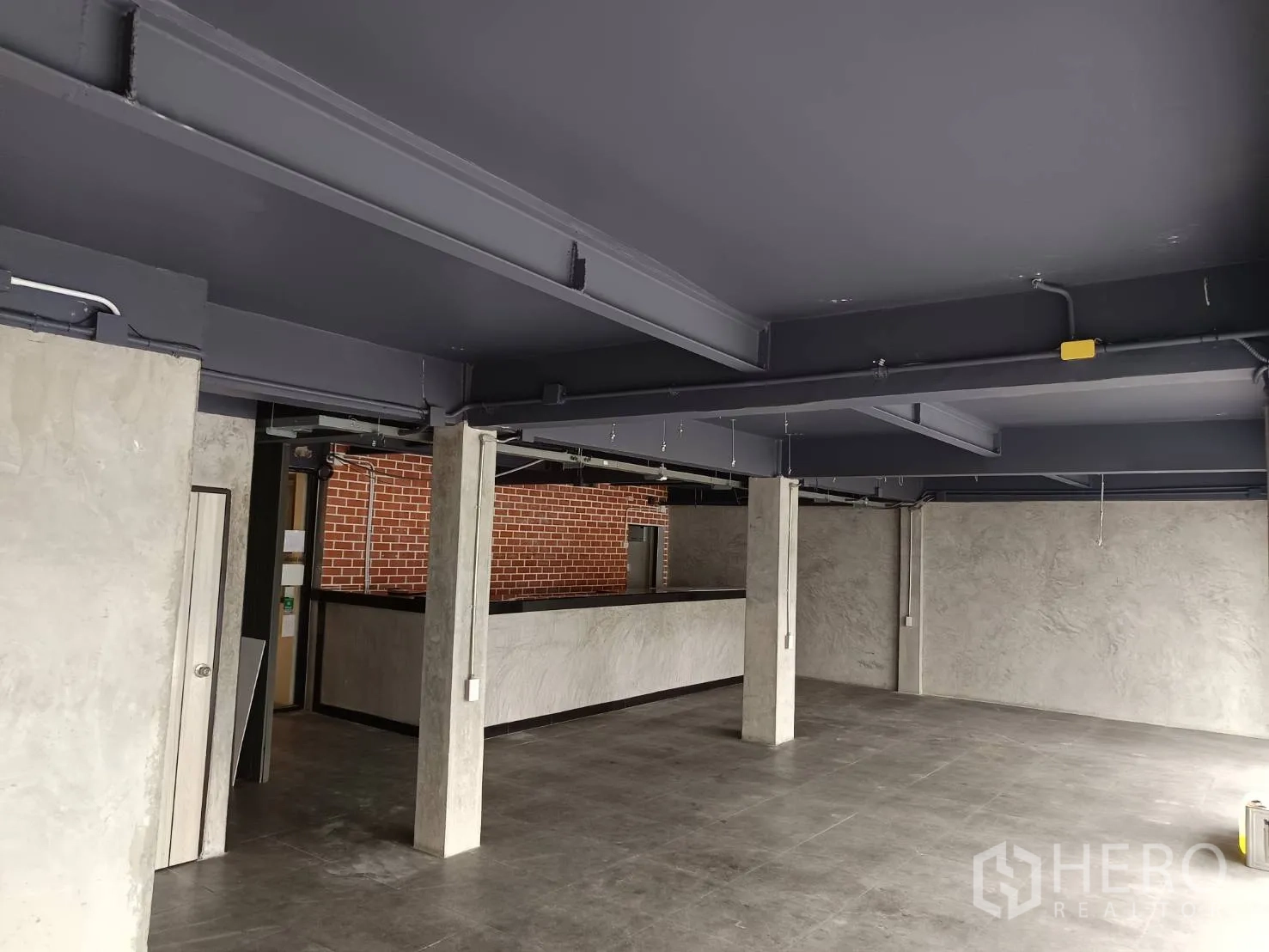 พื้นที่ขายปลีก ให้เช่าในWatthana, Bangkok - ห้องสไตล์อินดัสเทรียล โครงเหล็กโชว์ลาย เสาคอนกรีตและผนังเทา.