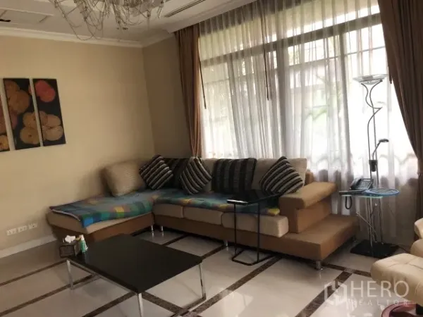Detached House for rent in Bang Phli, Samut Prakan - Bright living room featuring an L-shaped sofa, large window and chandelier on tiled floors.