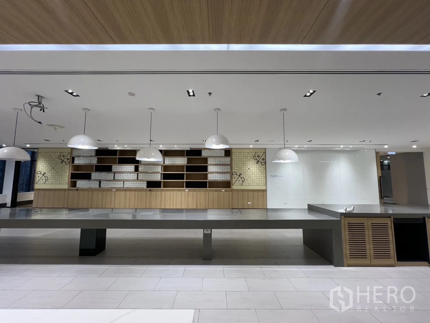 办公空间 出租在Huai Khwang, Bangkok - 茶水间背景墙，开放式搁架、吊灯与长工作台。