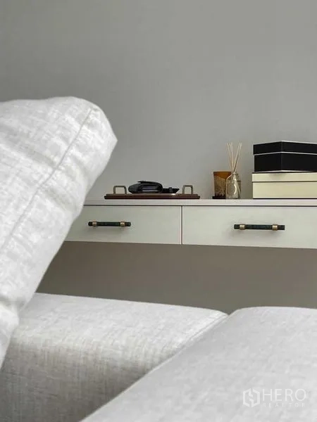 公寓 出售在Watthana, Bangkok - 极简抽屉柜与装饰摆件，置于浅灰色沙发后。