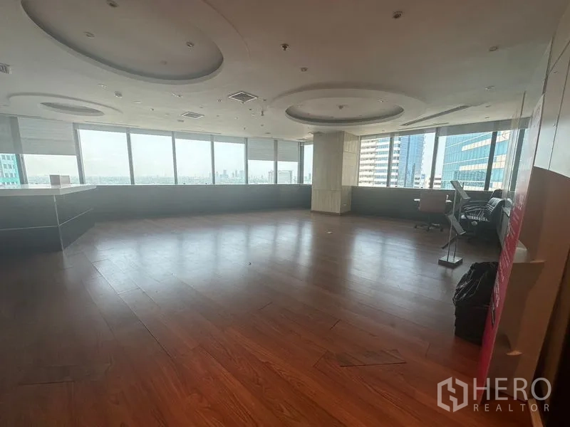 Office Space for rent in Khlong Toei, Bangkok - Large open-plan room with wood flooring and panoramic windows over Bangkok skyline.