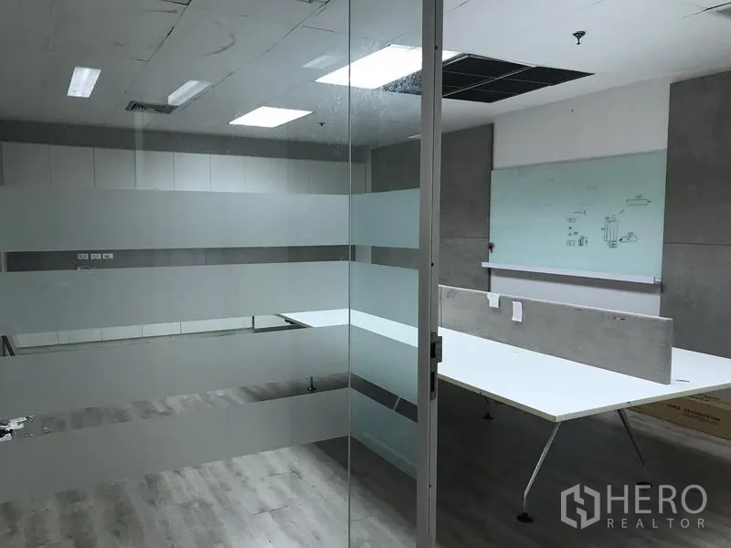 零售空间 出租在Pathum Wan, Bangkok - 玻璃隔断办公区，磨砂条纹玻璃、吊顶灯与内置工作台。