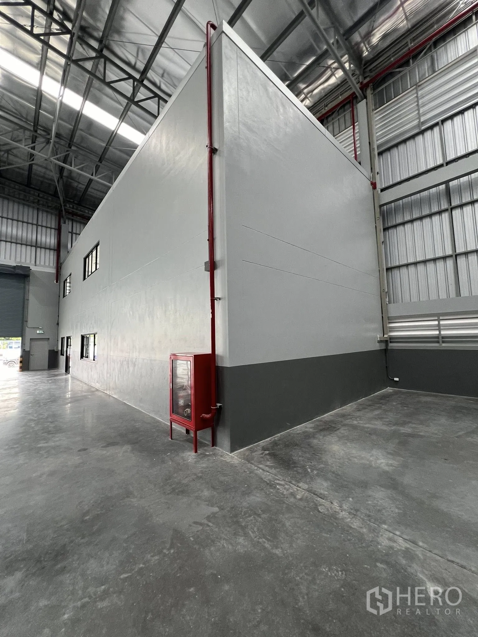Warehouse for rent in Phra Pradaeng, Samut Prakan - Side of the internal office structure with a fire hose cabinet and piping installed.