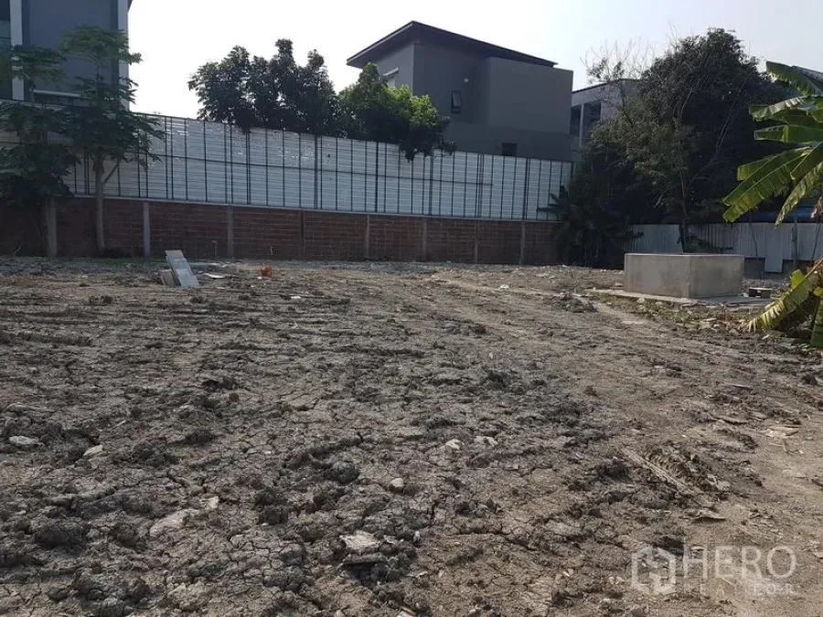 ที่ดิน ให้เช่าในPhra Khanong, Bangkok - พื้นดินแปลงว่างพร้อมล้อมรั้วอิฐและเมทัลชีท มีต้นไม้และบ้านสมัยใหม่ใกล้ถนนสุขุมวิท