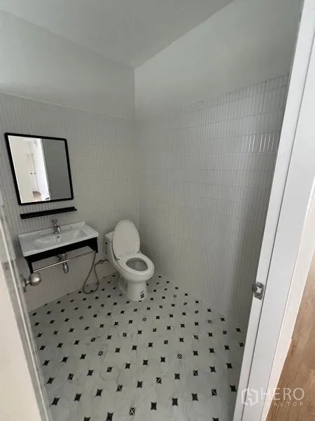 สำนักงานที่บ้าน ให้เช่าในHuai Khwang, Bangkok - ห้องน้ำกระเบื้องสีขาวพื้นลายขาวดำ มีอ่างล้างหน้า กระจก และโถสุขภัณฑ์