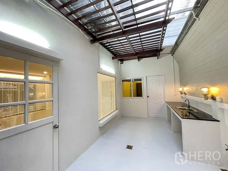 Townhouse for rent in Yan Nawa, Bangkok - Semi-outdoor Thai kitchen with skylight roof, long countertop and sink.