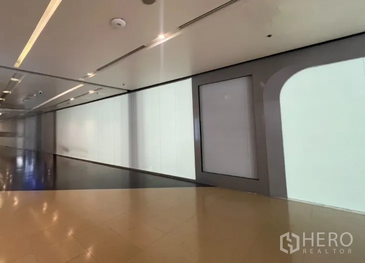 Retail Space for rent in Pathum Wan, Bangkok - Long white-paneled storefront stretching along a polished corridor.