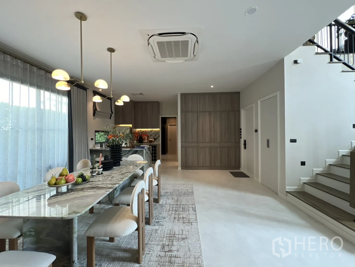 บ้านเดี่ยว for rent in Bang Phli, Samut Prakan - โซนรับประทานอาหารและครัว โต๊ะหินอ่อนยาว โคมไฟแขวน และตู้บิลต์อิน