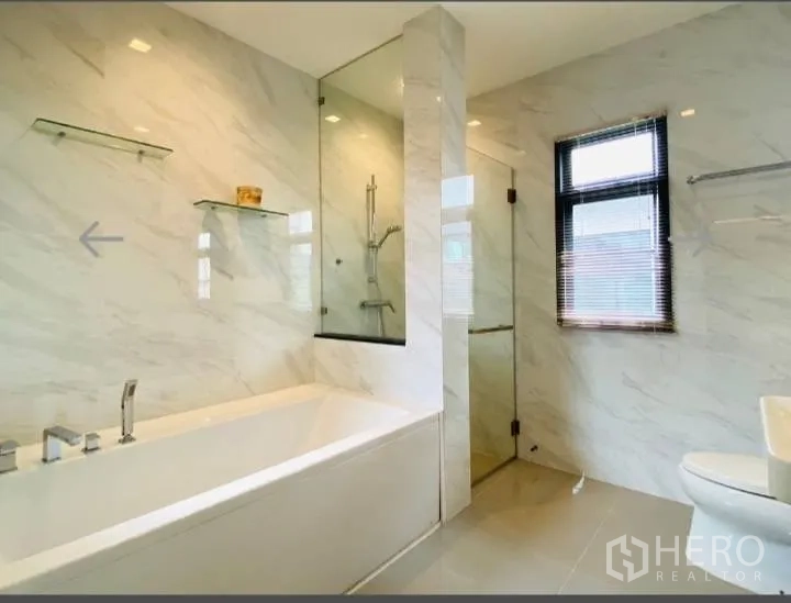 Detached House for sale in Saphan Sung, Bangkok - Bathroom with built-in bathtub, glass shower and window.