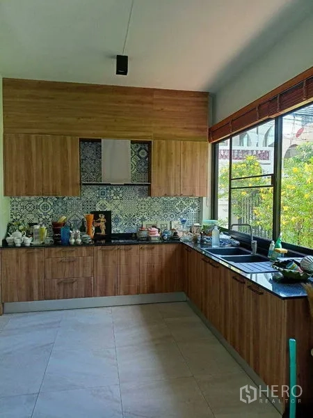 Home Office for rent in Watthana, Bangkok - L-shaped kitchen with wood cabinets, patterned backsplash and garden-view window.