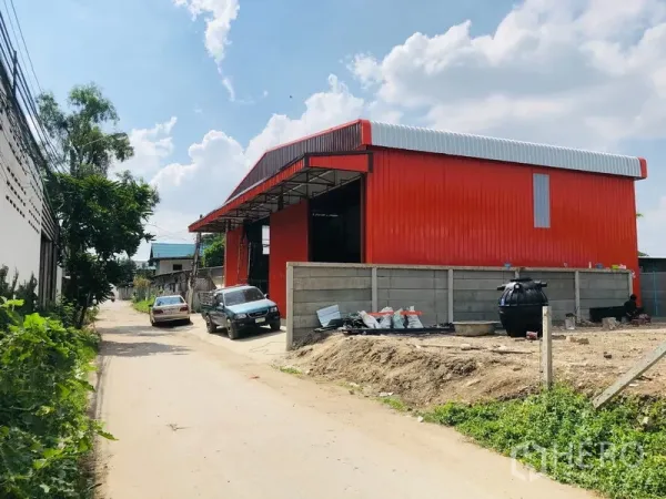 คลังสินค้า ให้เช่าในBang Kapi, Bangkok - ภายนอกโกดังสีแดง โครงเหล็ก หลังคาทรงจั่ว ติดถนนพร้อมที่จอด