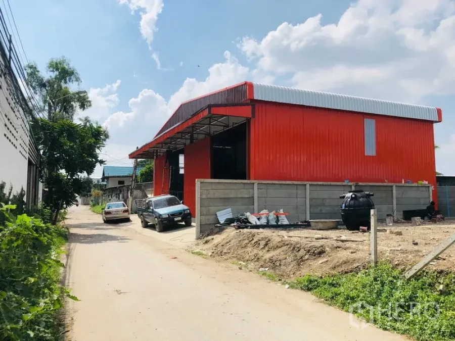คลังสินค้า ให้เช่าในBang Kapi, Bangkok - ภายนอกโกดังสีแดง โครงเหล็ก หลังคาทรงจั่ว ติดถนนพร้อมที่จอด