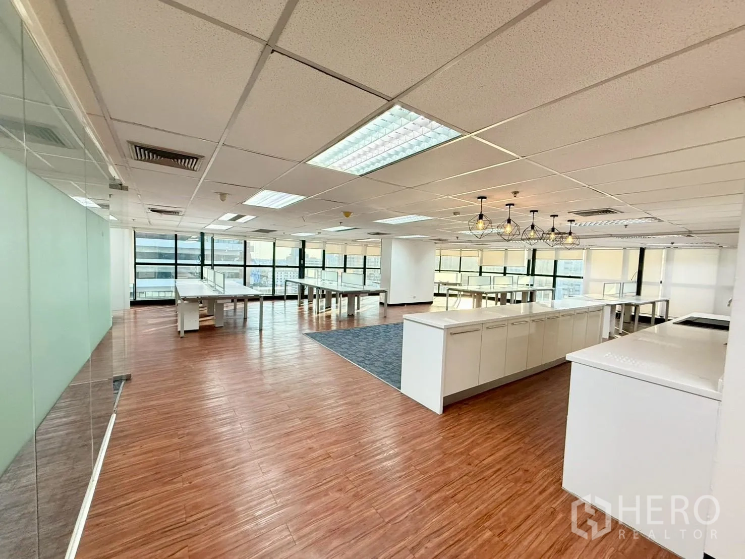 ออฟฟิศ for rent in Watthana, Bangkok - ออฟฟิศกว้างมีเคาน์เตอร์แพนทรียาว ผนังกระจก พื้นลายไม้ และวิวเมือง.