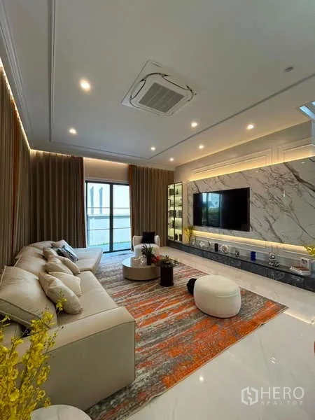 Detached House for sale in Bang Kapi, Bangkok - Family lounge with large sofa, marble media wall and floor-to-ceiling drapes.