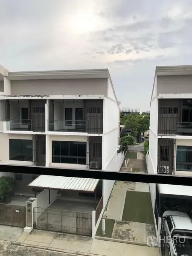 联排别墅 出租在Lat Phrao, Bangkok - 安静街巷中的现代三层联排别墅外观，带阳台与车棚。