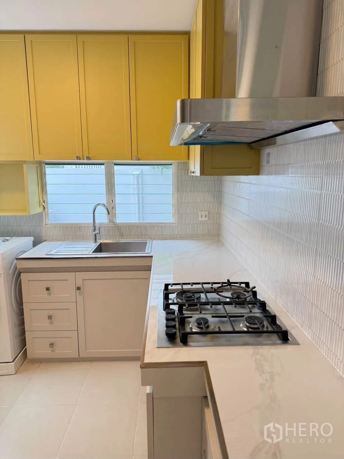 Detached House for rent in Bang Phli, Samut Prakan - Fitted kitchen with yellow cabinets, gas cooktop, hood, sink, and washer.