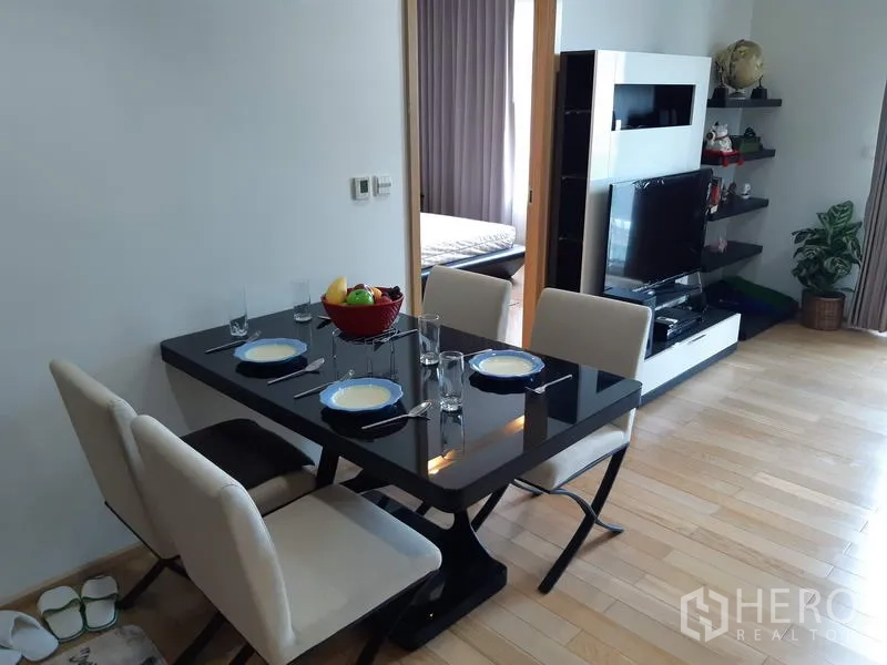 คอนโด ให้เช่าในKhlong Toei, Bangkok - มุมทานอาหารโต๊ะกระจกสีดำสำหรับสี่ที่นั่ง เชื่อมต่อห้องนั่งเล่นและทางเข้าห้องนอน