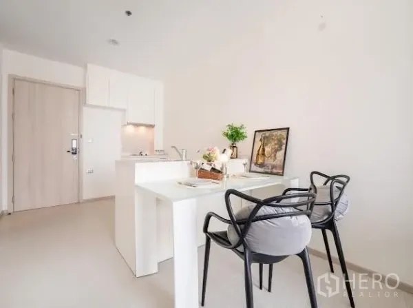 公寓 出售在Khlong Toei, Bangkok - 餐吧区设两把黑色椅子，紧邻紧凑型厨房。