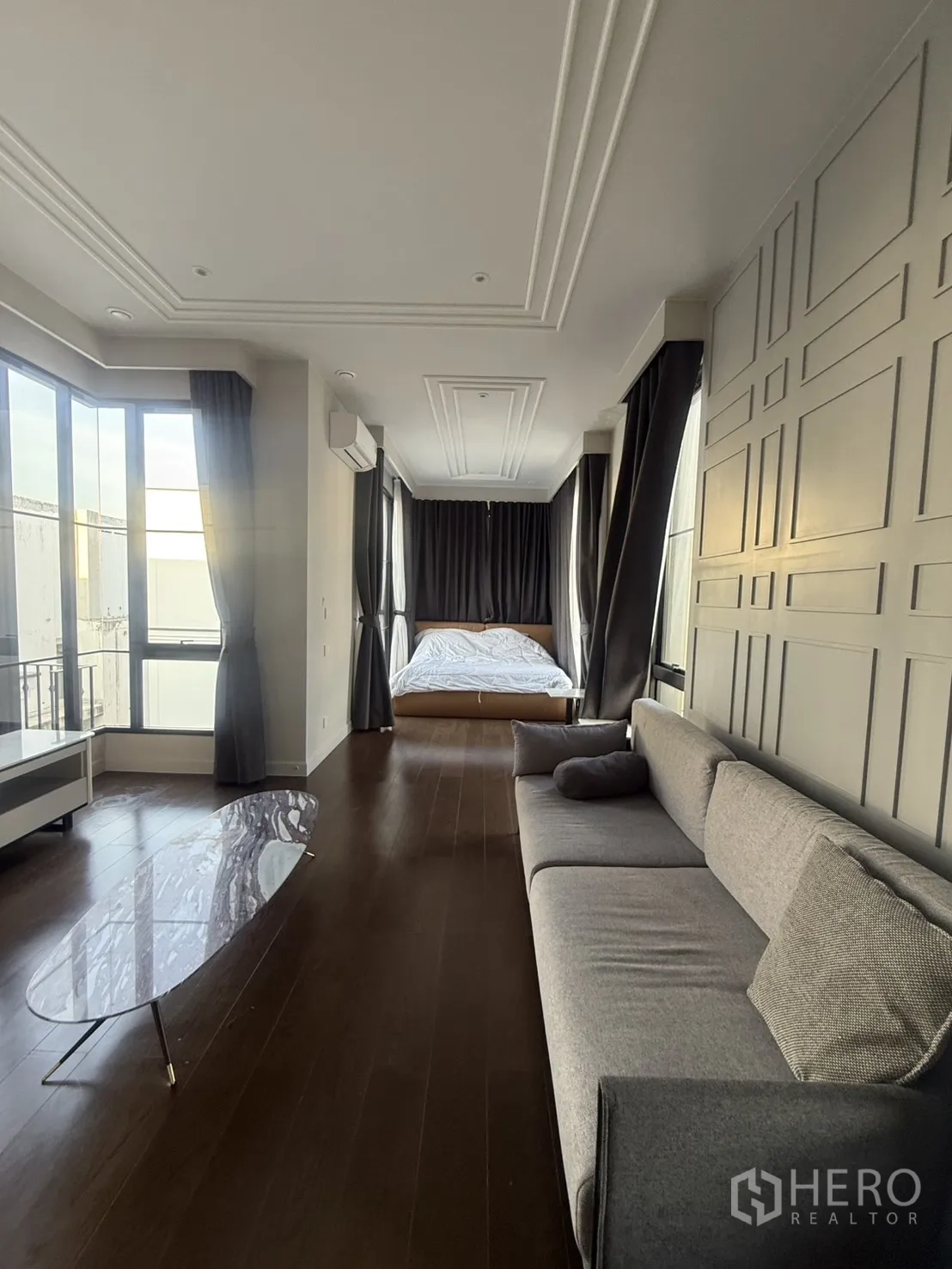 Detached House for rent in Saphan Sung, Bangkok - Long bedroom suite with sofa seating, bed and tall wraparound windows.