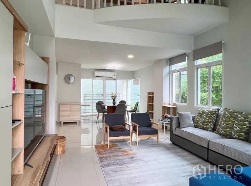 Detached House for rent or sale in Prawet, Bangkok - Bright open-plan living and dining room with high ceiling and large windows.