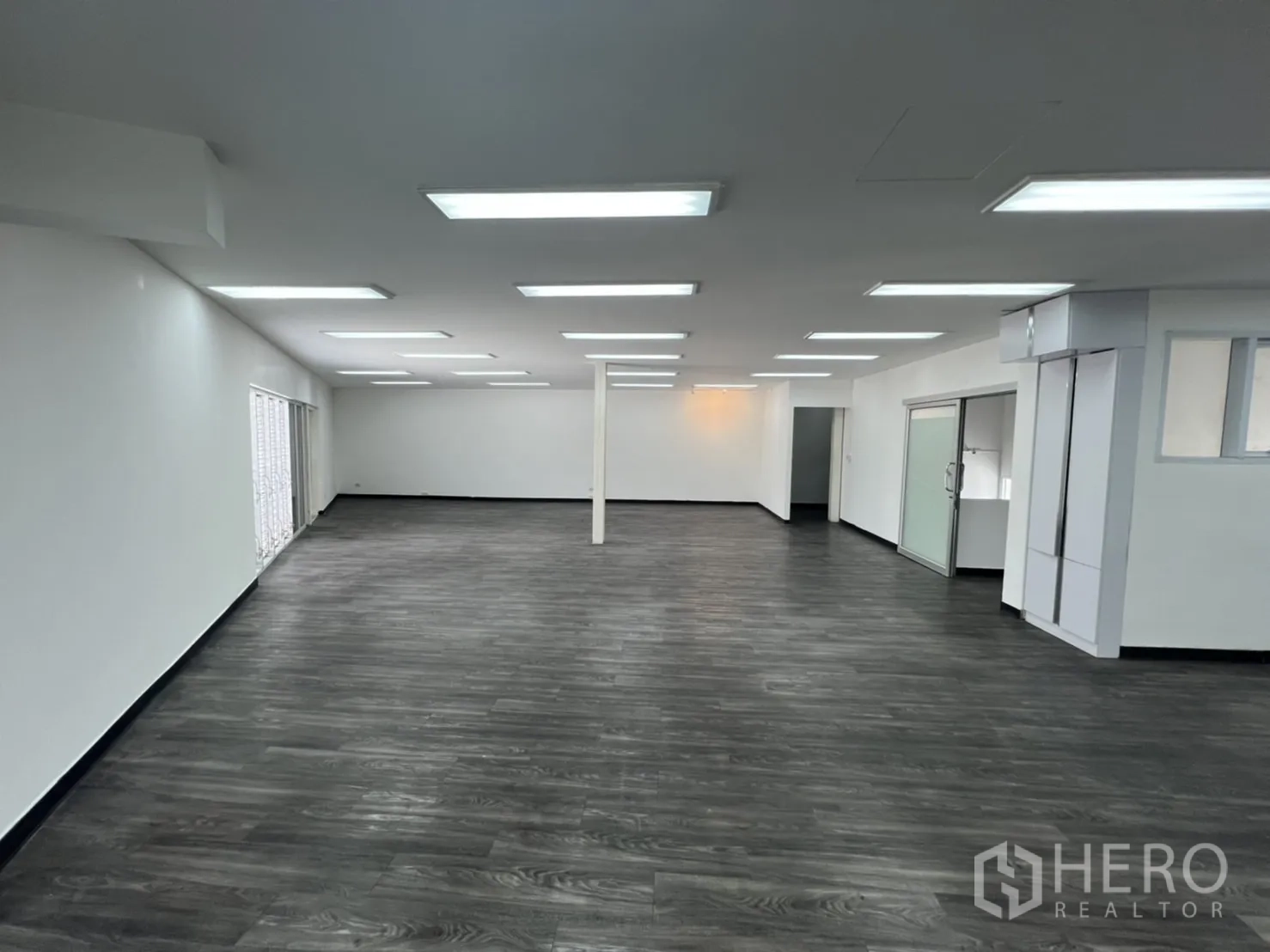 พื้นที่ขายปลีก ให้เช่าในSathon, Bangkok - พื้นที่ค้าปลีกสีขาวกว้าง พื้นไวนิลสีเทา และประตูกระจกเลื่อนด้านข้าง