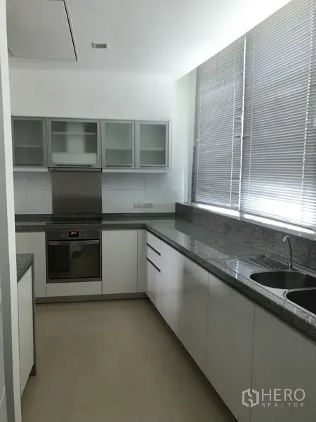 คอนโด ให้เช่าในKhlong Toei, Bangkok - ครัวแยกตู้สีขาว เคาน์เตอร์หินแกรนิต เตาอบบิลต์อิน และอ่างล้างจานคู่