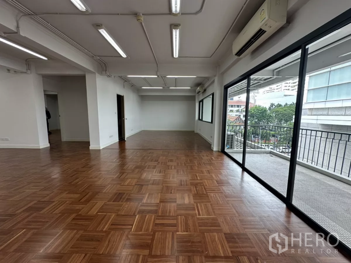 办公空间 出租在Watthana, Bangkok - 明亮开放式办公室，整面玻璃与阳台栏杆，配备空调机组。