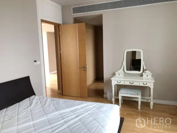 คอนโด ให้เช่าในKhlong Toei, Bangkok - ห้องนอนโทนอบอุ่น มีเตียงและโต๊ะเครื่องแป้งสีขาวพื้นไม้