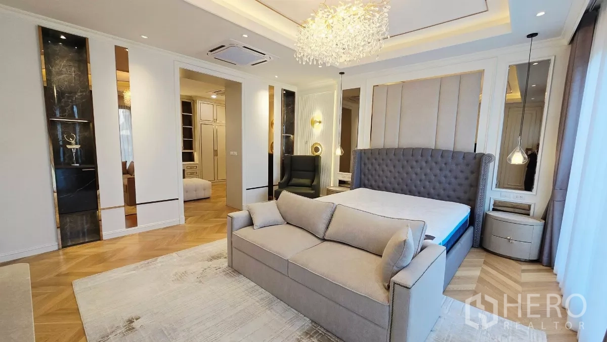 Detached House for rent in Prawet, Bangkok - Master bedroom with tufted headboard, sofa and chandelier.