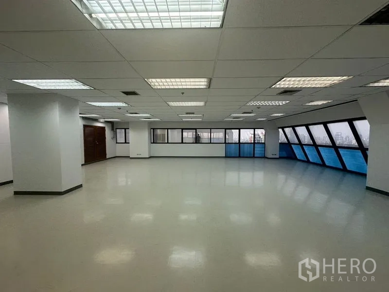 สำนักงาน ให้เช่าในPhaya Thai, Bangkok - สำนักงานสว่างโล่ง ไฟฝ้าหลายจุด เสาหลายต้น และหน้าต่างกระจกโทนฟ้าสองด้านของห้อง.