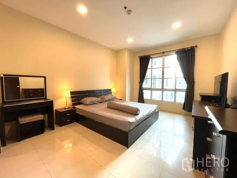 房间 出租在Khlong Toei, Bangkok - 宽敞主卧，配特大床、梳妆台和大窗帘窗