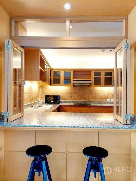 อพาร์ทเมนท์ ให้เช่า - เคาน์เตอร์บาร์เปิดเชื่อมครัวรูปตัว U พร้อมหน้าต่างบานเฟี้ยมและสตูลสองตัว