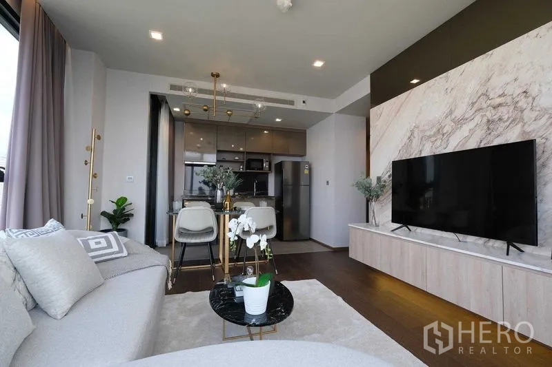 คอนโด ให้เช่าในKhlong Toei, Bangkok - ห้องนั่งเล่นแบบเปิด ผนังทีวีลายหินอ่อน โซฟาขนาดใหญ่ติดกับครัว