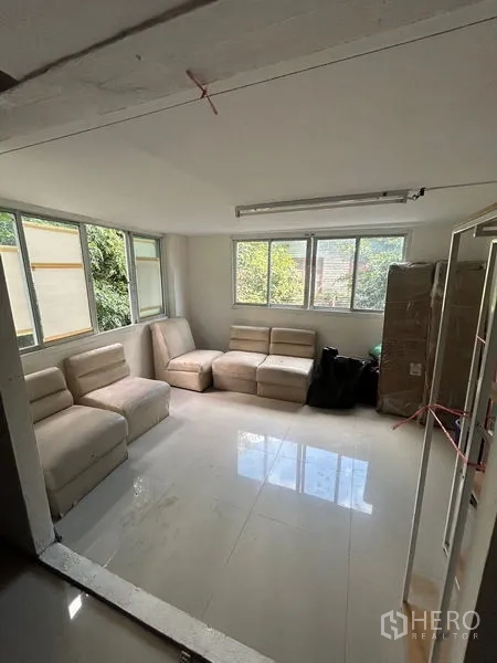 อาคารพาณิชย์ ให้เช่าในKhlong Toei, Bangkok - ห้องรับรองสว่าง พื้นกระเบื้องสีขาว โซฟาโมดูลาร์ และหน้าต่างบานกว้างมองเห็นต้นไม้