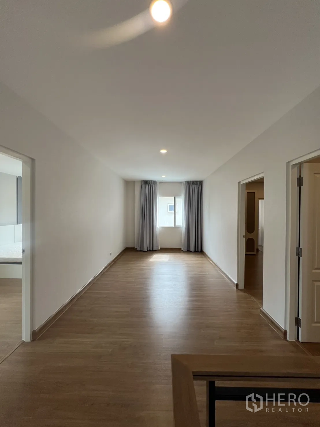 Detached House for rent in Lat Krabang, Bangkok - Upstairs landing with wood flooring, recessed lights, and a curtained window.