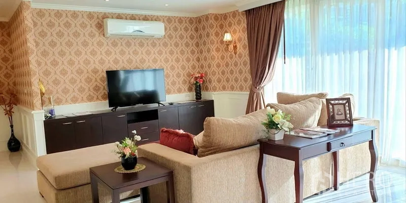 อพาร์ทเมนท์ ให้เช่าในWatthana, Bangkok - มุมนั่งเล่นพร้อมโซฟาตัวแอล ตู้ทีวี และประตูกระจกสูงเปิดสู่สวน