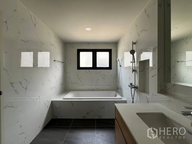 Detached House for rent in Bang Phli, Samut Prakan - Bathroom with bathtub, shower and marble-look wall tiles.