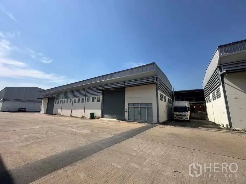 货栈 出租在Bang Bua Thong, Nonthaburi - 暖武里邦布通现代仓库外观，宽阔混凝土装卸场地