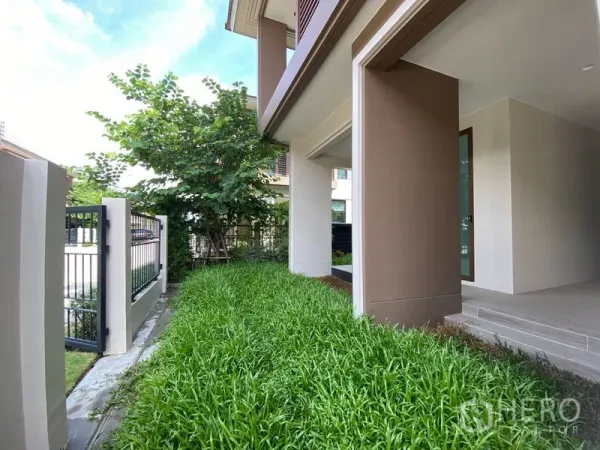 บ้าน ให้เช่าในBang Kapi, Bangkok - สวนข้างบ้านปูหญ้าเขียวและรั้วเหล็กตลอดแนวบ้าน