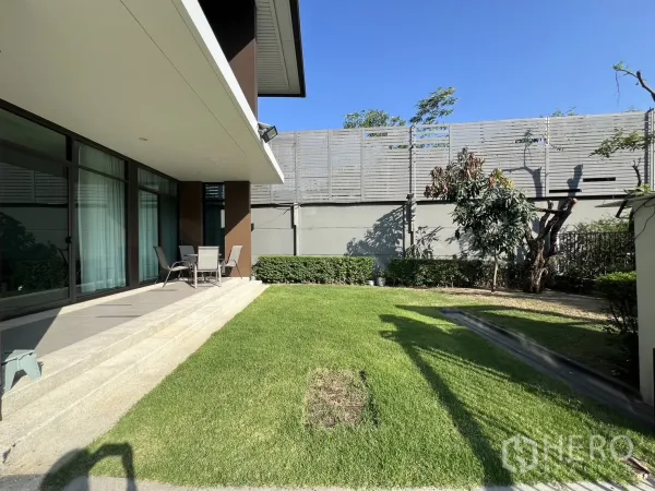 Detached House for rent or sale in Bang Kapi, Bangkok - Side garden with lush green lawn, terrace steps and tall privacy fence along the boundary.