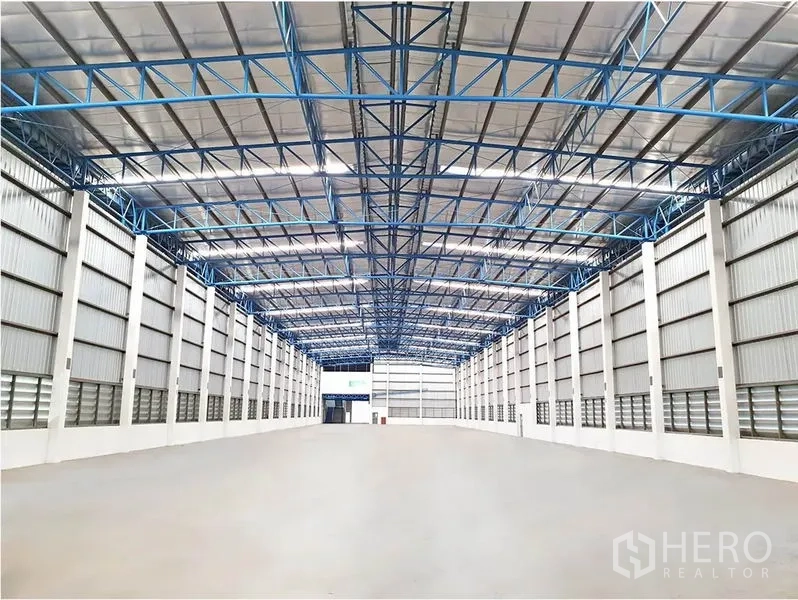 คลังสินค้า ให้เช่าในLat Krabang, Bangkok - พื้นที่ภายในโกดังแบบสแปนกว้าง หลังคาสูงมีฉนวน คานเหล็กสีน้ำเงิน และพื้นคอนกรีตขัดมัน
