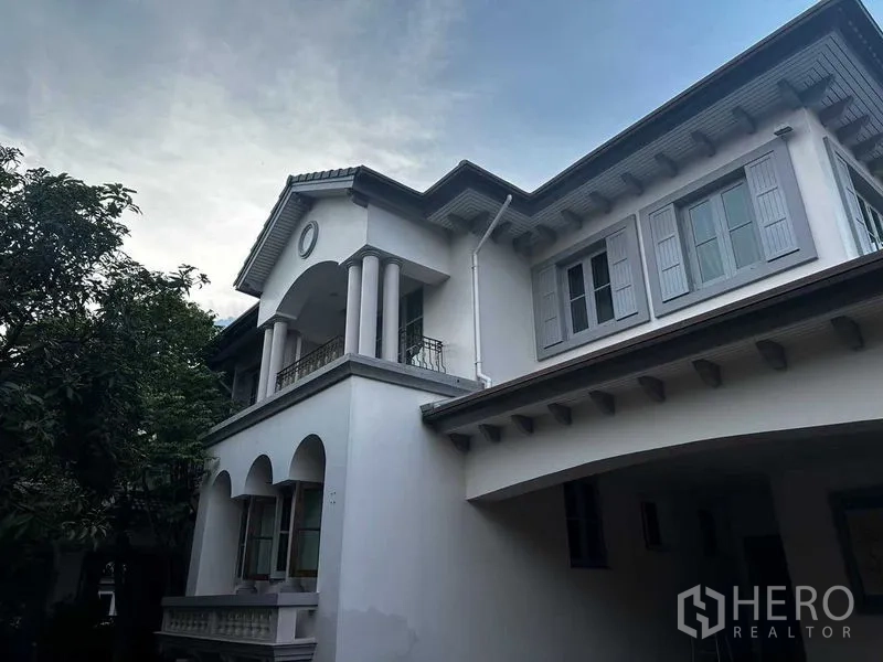 Detached House for sale in Bang Khun Thian, Bangkok - Two-storey exterior with balcony, columns and shuttered windows.