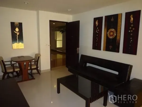 Condominium for rent or sale in Khlong Toei, Bangkok - Wide view of living and dining area with glossy tiled floors and contemporary Thai artwork.