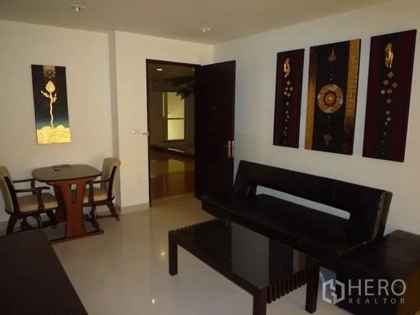 Condominium for rent or sale in Khlong Toei, Bangkok - Wide view of living and dining area with glossy tiled floors and contemporary Thai artwork.