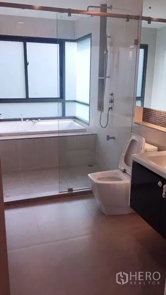 Detached House for rent in Bang Kapi, Bangkok - Modern bathroom with a glass-enclosed shower, bathtub and vanity.